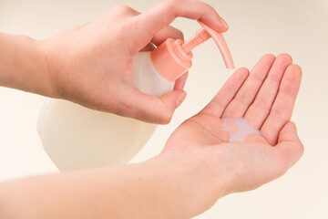 Bottle with liquid soap in female hands