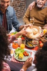 Selective focus of man looking at african american woman holding bun on thanksgiving