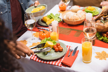 cropped view of man taking corn during thanksgiving dinner