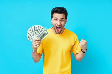 Happy excited man showing money banknotes on blue background
