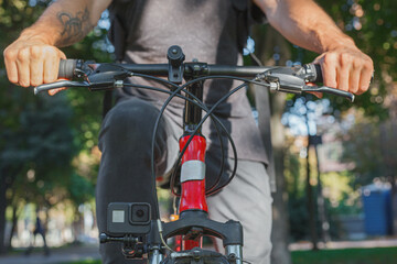 Action camera fixed next to the wheel of the bicycle on which the man rides