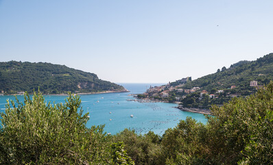 Fototapeta na wymiar Portovenere, Liguria, Italy. June 2020. Sea view from the village hill: a magnificent view of the bay crossed by numerous boats of various sizes.