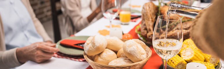 selective focus of delicious buns, corn and glass of white wine on table, served on thanksgiving...