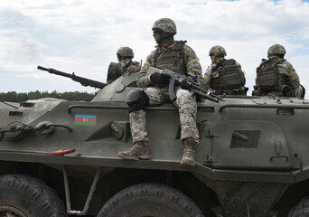 Flag of Azerbaijan on an armored personnel carrier and soldiers with machine guns. Military Conflict in the Caucasus. Collage.