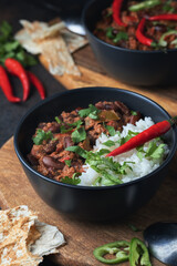 Hot chilli con carne with minced beef, vegetables, rice. Topped with chilli pepper. Mexican food tasty and spicy.