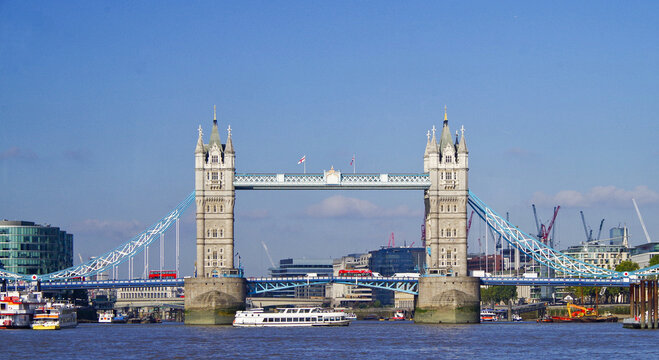Famous London city landmark Tower Bridge is a popular Tourist sightseeing spot in downtown London over the River Thames with city skyline, boats and buildings