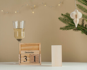 Wooden calendar on December 31 and Empty podium for your product. New year background. A glass of wine, a tree branch