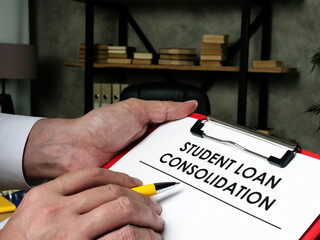 Man fills out the form for student loan consolidation.