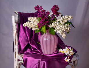 Lillac bouquet in vase on Vintage wooden chair
