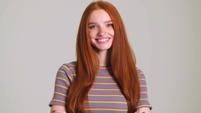 Young cheerful redhead cute woman posing isolated over white wall background