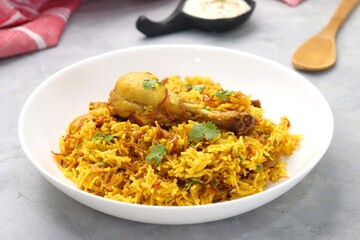 Chicken Biryani/murg Pulao.  Garnished with fried onion & chopped coriander. Biryani served with raita is a famous Spicy non vegetarian dish of India. Along with copy space.