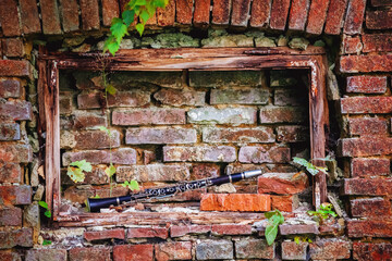 Old clarinet on background of beautiful broken brick wall. Copy space for text or design.