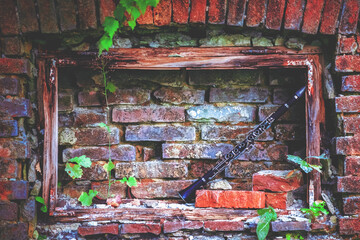Old dirty clarinet on background of beautiful old brick wall. Copy space for text or design.