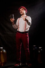 Portrait of Oktoberfest funny young man or guy in traditional national ethnic clothes and hat with mug of beer posing at studio. Concept celebration of festival. Male model in advertising photosession