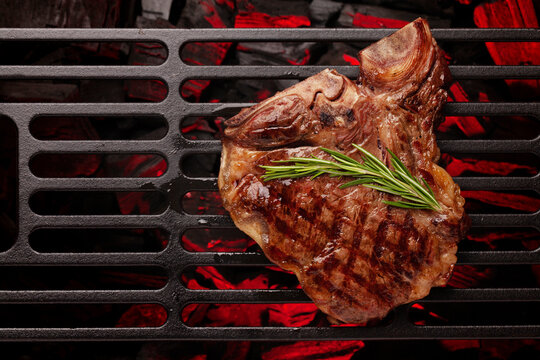 T-bone beef steak cooking on grill