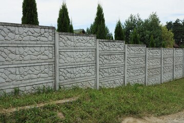 long private concrete gray fence on a rural street