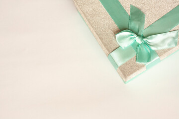 Fototapeta na wymiar Silver gift box with blue bow, flat lay, copy space