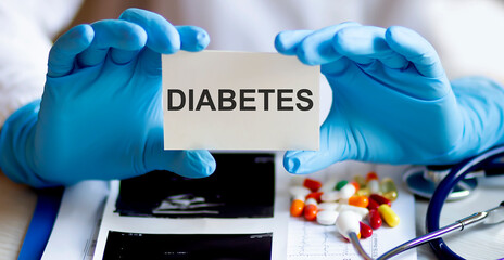 text DIABETES write on a medicine card. Medical concept with a stethoscope and pills