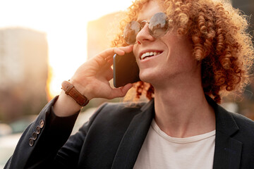 Happy ginger guy speaking on smartphone