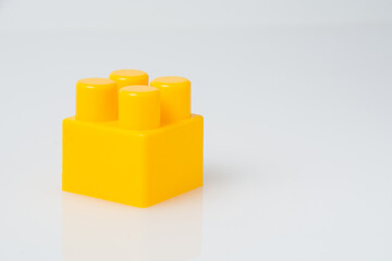 Fototapeta premium Yellow cube block constructor on a white background with copy space. Construction idea concept