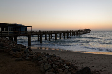 "Swakopmund Jetty" Hölzerne Brücke im Meer bei Sonnenuntergang am Strand von Swakopmund, Namibia