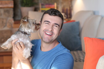 Man in sofa with small dog 