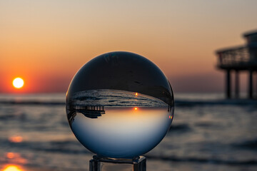 The setting sun at the Pier in Scheveningen is inverted in the Lens Ball