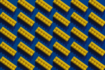 Pattern of many yellow cubes of the constructor on a blue background.