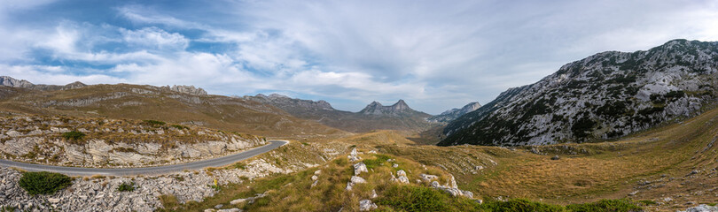 Fototapeta na wymiar Beautiful panorama on top of Durmitor mountain. Serpentine road and unbelievable view to mountains of Montenegro. Lovely sky with clouds.