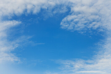Fototapeta premium Clear blue sky in center of white clouds around.