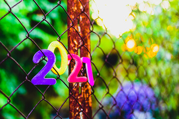 numbers of different colors 2021 new year on a metal mesh chain-link