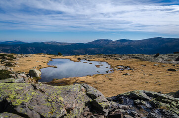 Fototapeta premium Small lake on a rocky mountain landscape on Guadarrama mountain range, Peñalara, Madrid, Spain