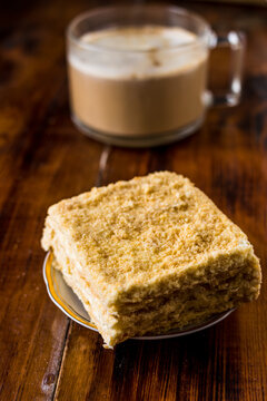 A Big Glass Mug Of Cacao With Milk And A Slice Of Cake On Wooden Table

