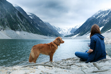 dog and a girl at mountain lake. hiking with pet. Woman and pet travels