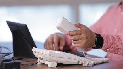 Fototapeta premium Holding handset of the telephone and working in laptop