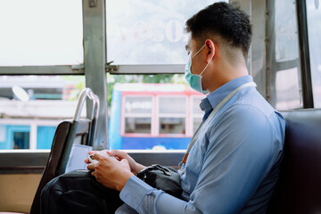 Business man using smartphone on a bus.