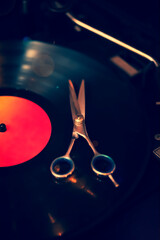 Close up of scissors on vinyl record. Barber shop.