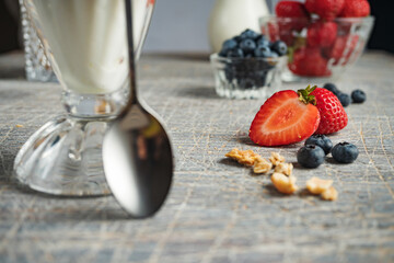 Ice cream with strawberries and blueberries in a tall glass, close up