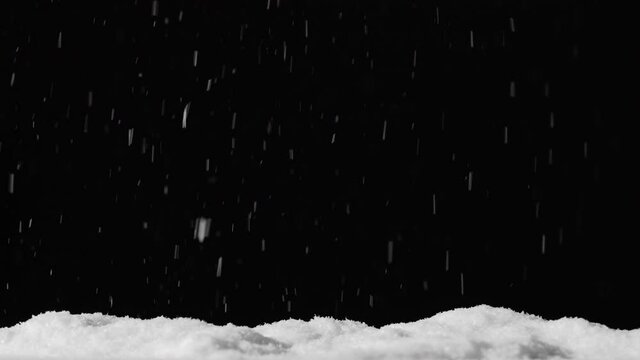 Snow background. Winter night. Blur white flakes falling on pile isolated on black. Defocused ice particles motion on dark sky. Christmas blizzard.