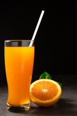 Fresh orange juice on wooden background with dark light .