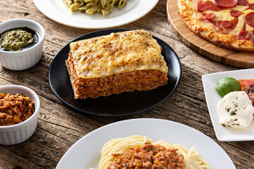 Assortment of Italian pasta dishes on wooden table.	