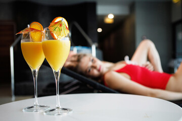 Two wine glasses with orange juice on the table.
