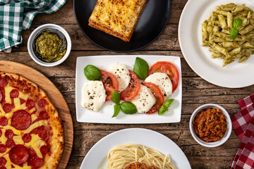 Assortment of Italian pasta dishes on wooden table.	
