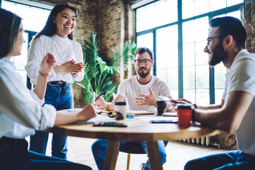 Laughing diverse colleagues discussing business ideas