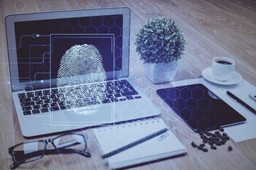 Computer on desktop in office with finger print drawing. Double exposure. Concept of business data security.