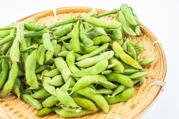 Fresh edamame in a pot on white background