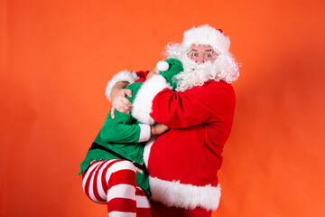Couple. Funny santa claus. Orange background.