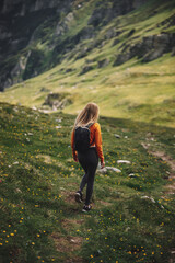 Fototapeta premium Young woman backpacker walking on a pathway in the mountains. Discovery Travel Destination Concept. Bucegi Mountains,Romania,Transylvania.