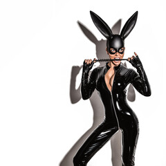 Halloween sexy girl in bunny costume. Sexy blonde beautiful woman posing in latex costume and black...