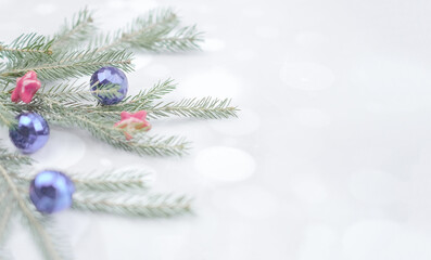 Fototapeta na wymiar Soft lights background for christmas with fir branches, balls and stras, with copy space, bokeh